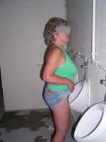 Mature slut pissing in a urinal